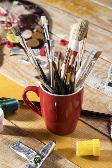 angle eleve d assortiment de pinceaux dans une tasse avec palette